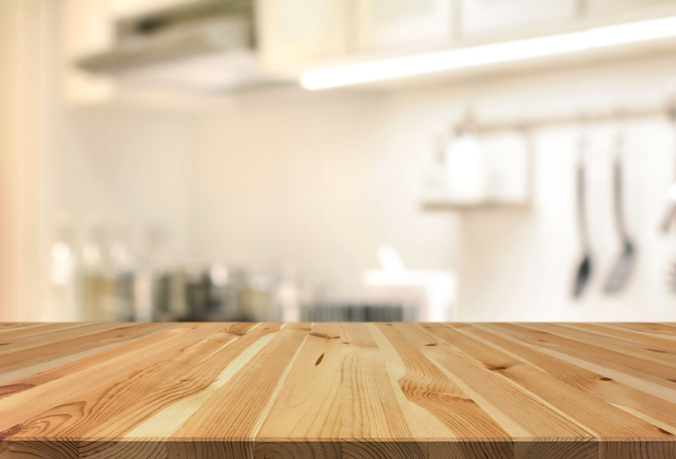 Wooden kitchen island with blurred kitchen in the background