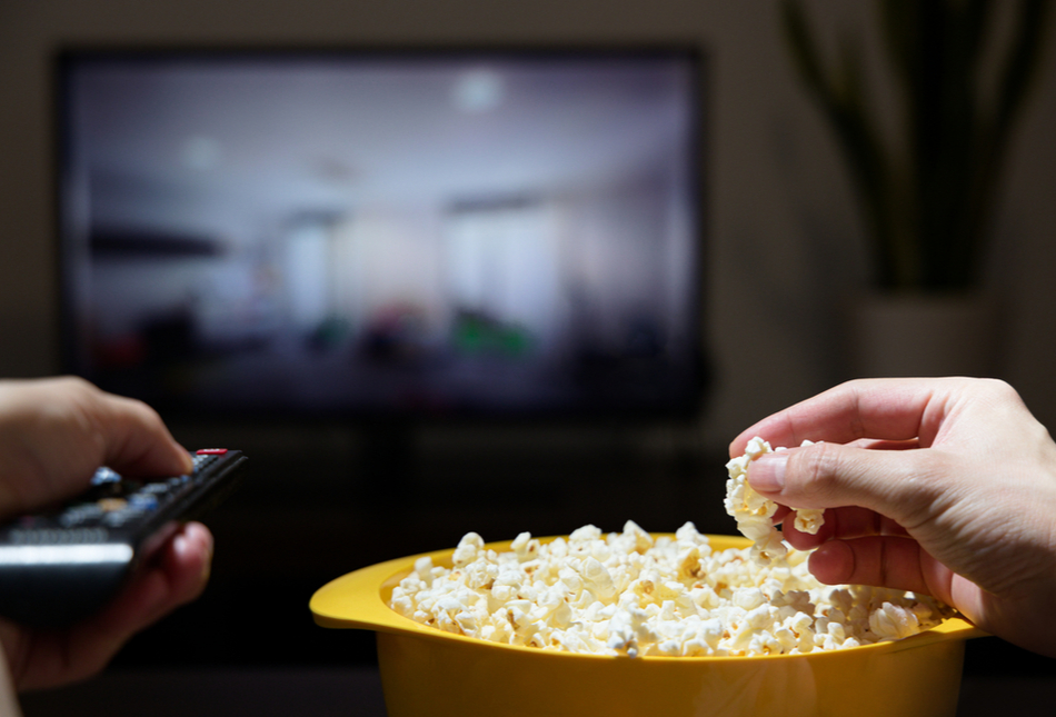 Bowl of popcorn with a TV screen in the background