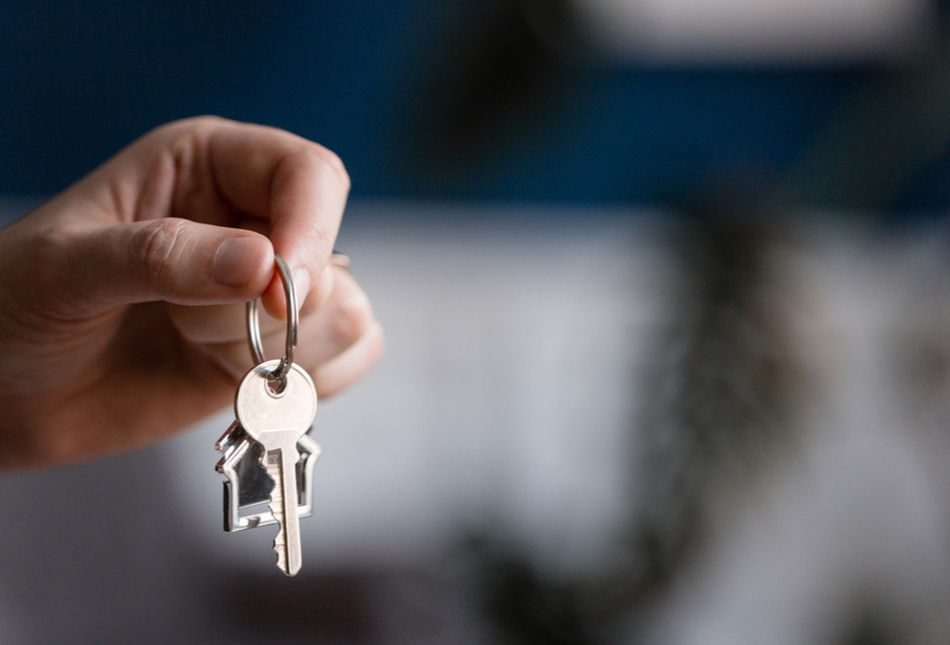 A hand holding up some house keys