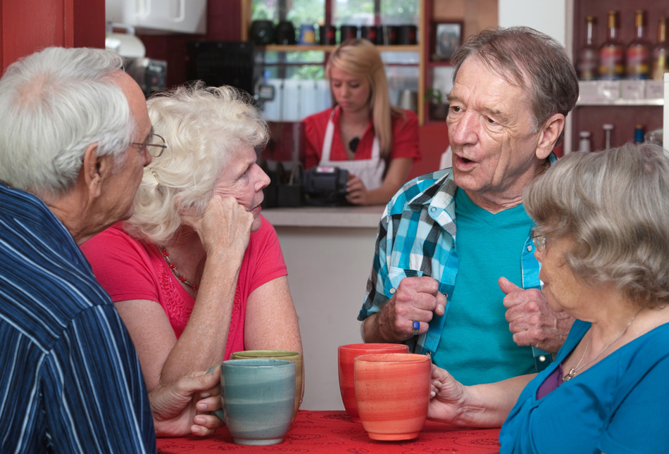 Four senior adults drinking coffee in a cafe