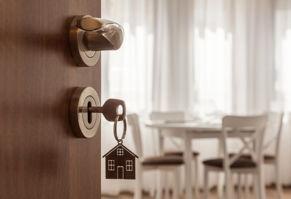 A key in a front door with a house keyring