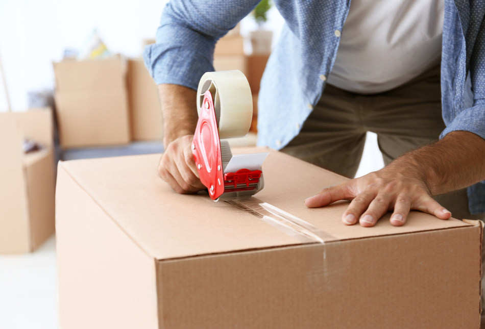 A man packing cardboard boxes to move home.