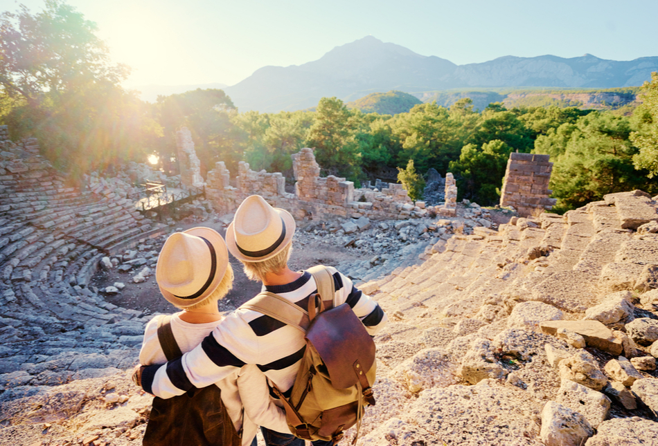 A mature couple enjoying the view of an ancient amphitheatre.