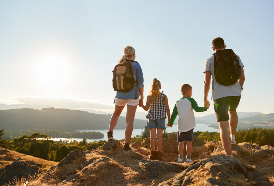 A family standing at the top of a hill in the Lake District, UK.