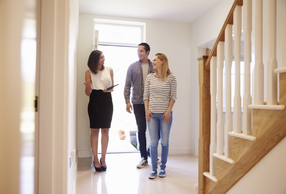 An estate agent showing a couple around an empty home.