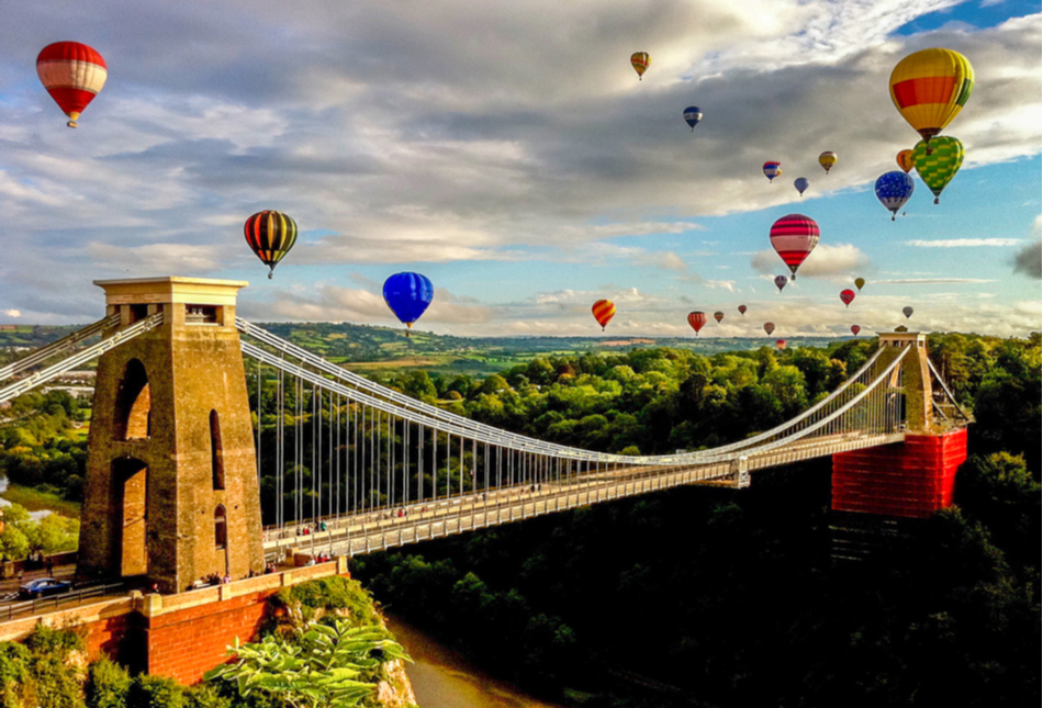 Hot air balloons in flight over the Clifton Suspension Bridge during the Bristol International Balloon Fiesta.