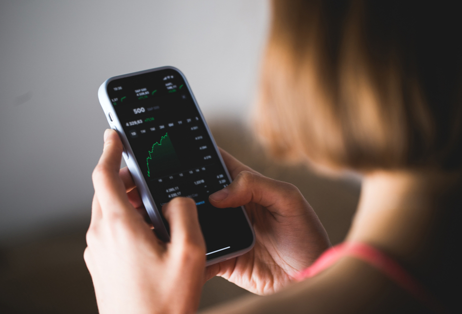 a woman looking at investments on her phone