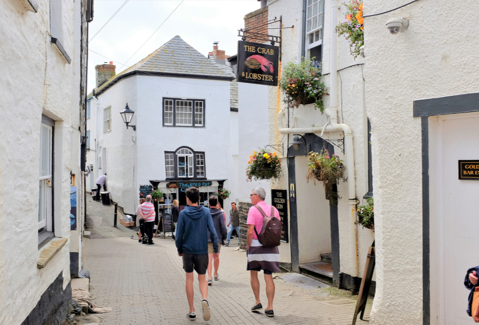 People walking down a street in Cornwall, UK.