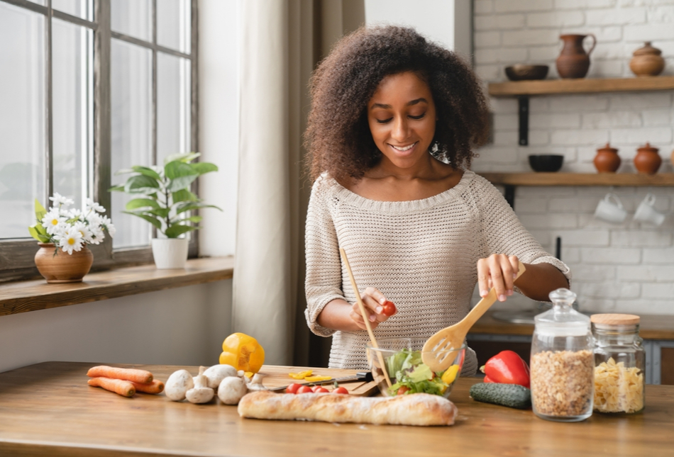 A person making a salad with fresh ingredients