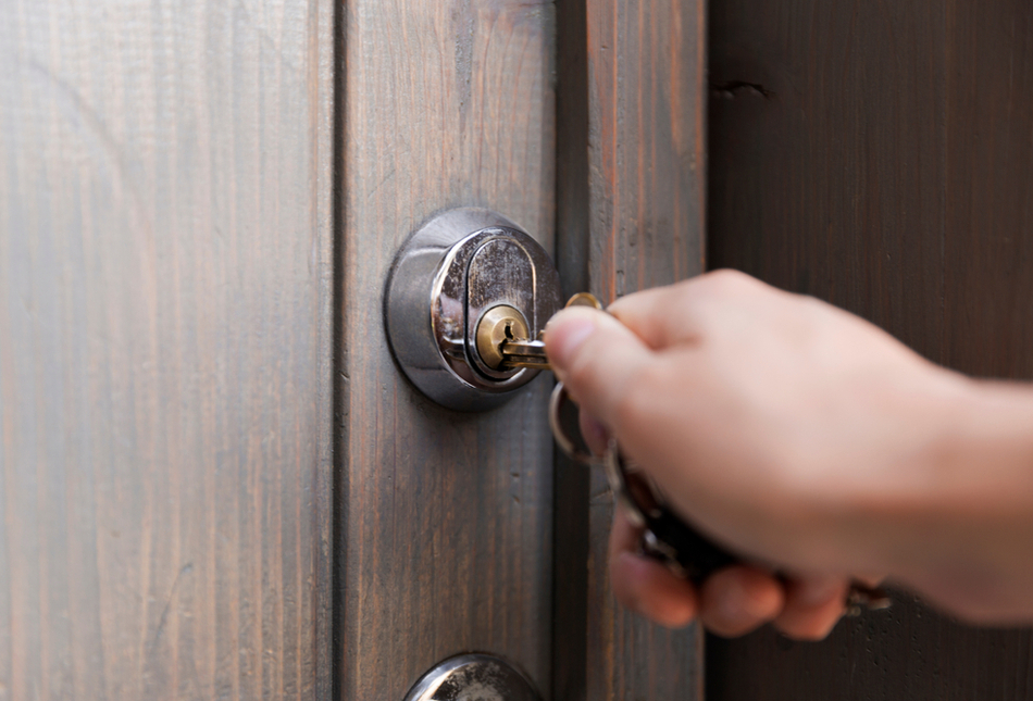 Someone opening a front door with a key.