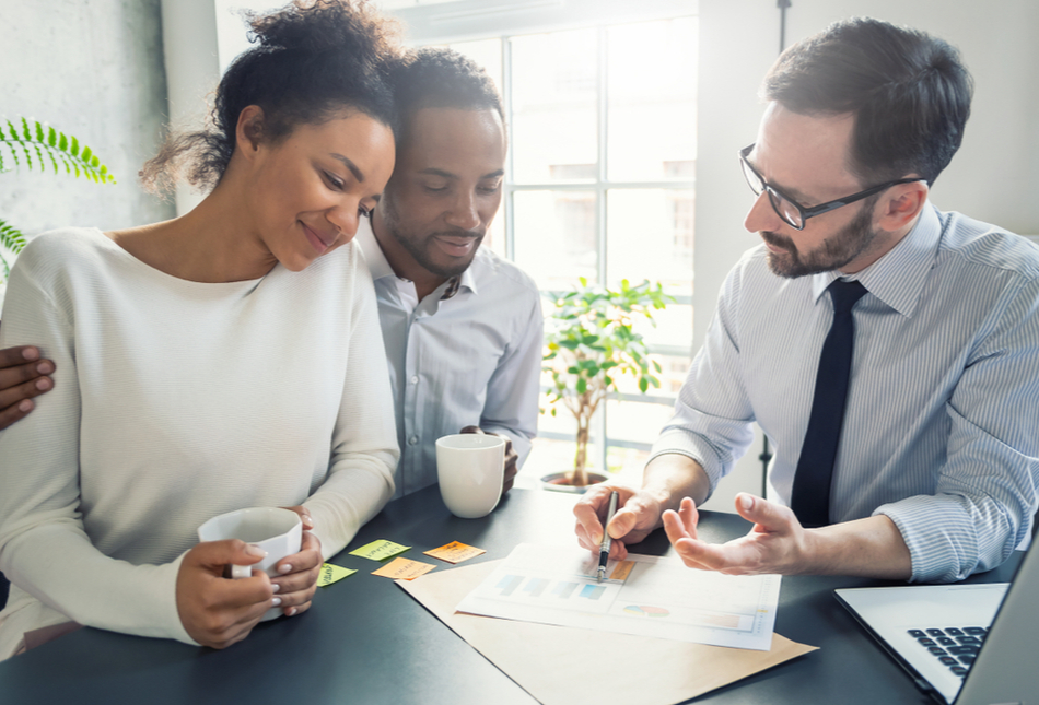 A couple reviewing paperwork with a professional.