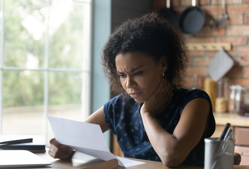 A concerned woman reads a bill