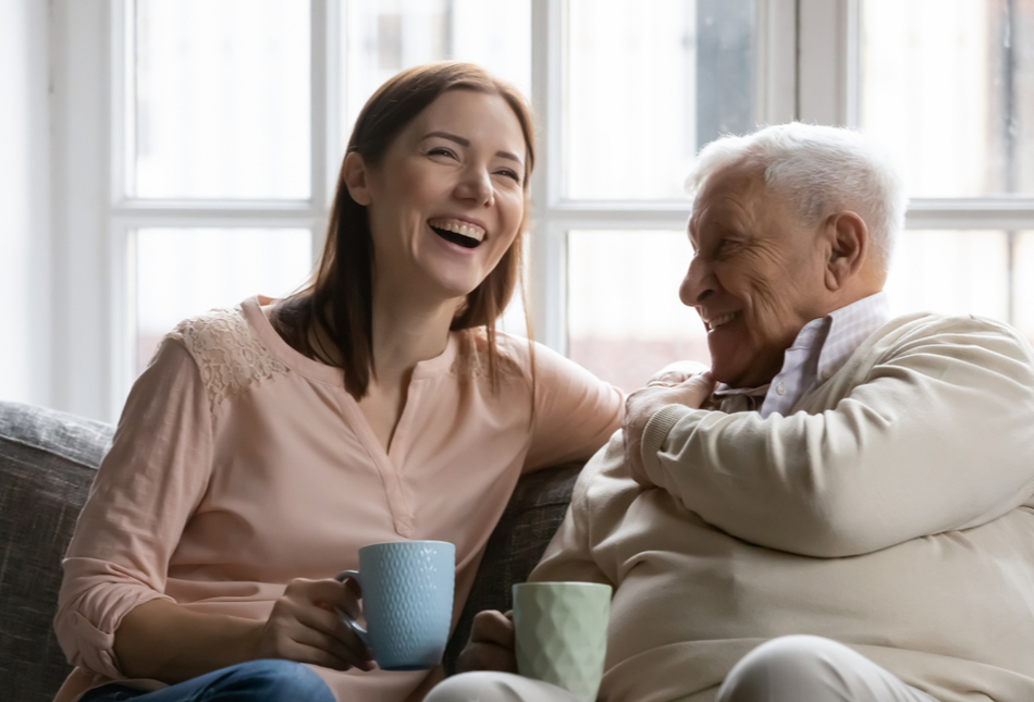 A woman sharing a cup of tea with her father.