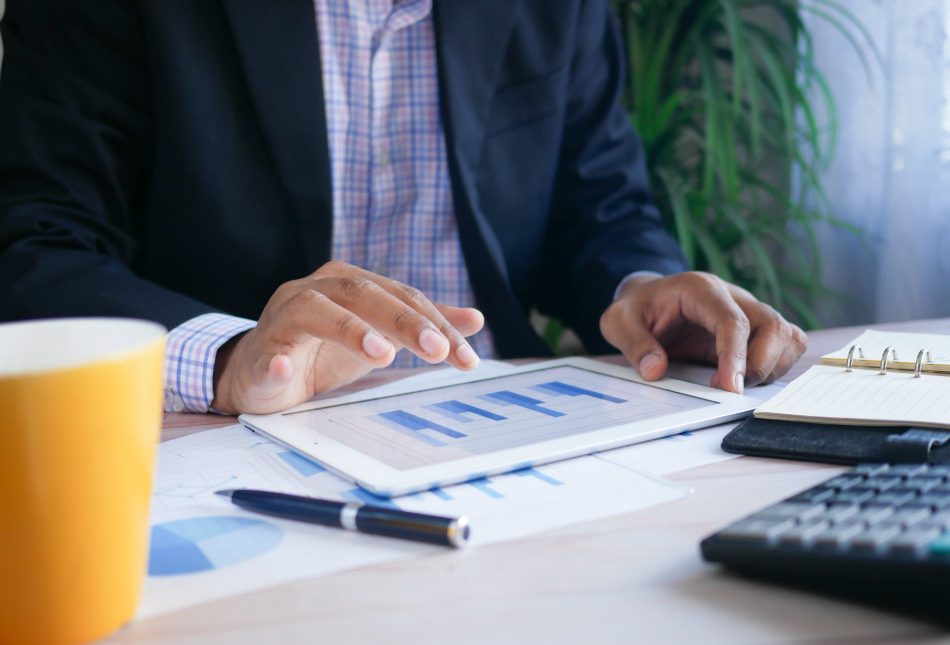 Business man looking at charts on a tablet.