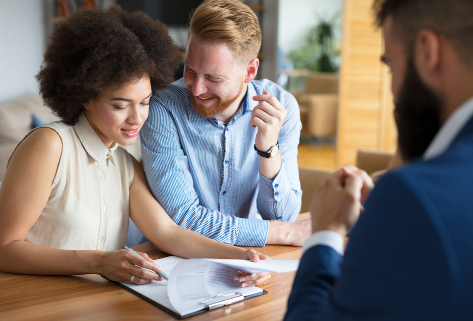 A couple filling out a mortgage application with a mortgage broker.