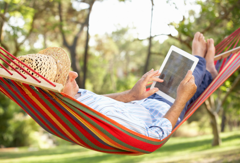 A man in a hammock using a tablet.