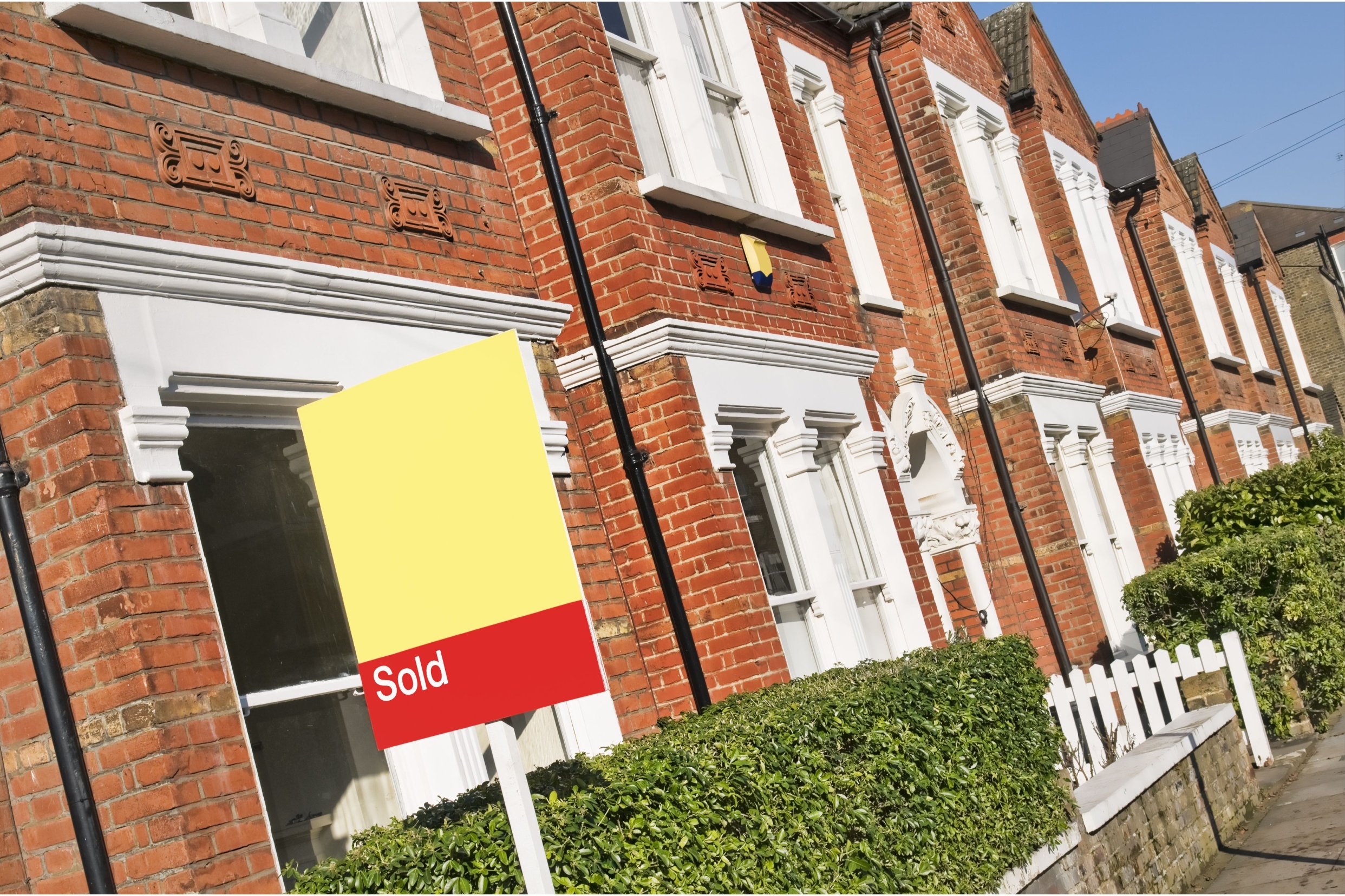A house with a “sold” sign outside.
