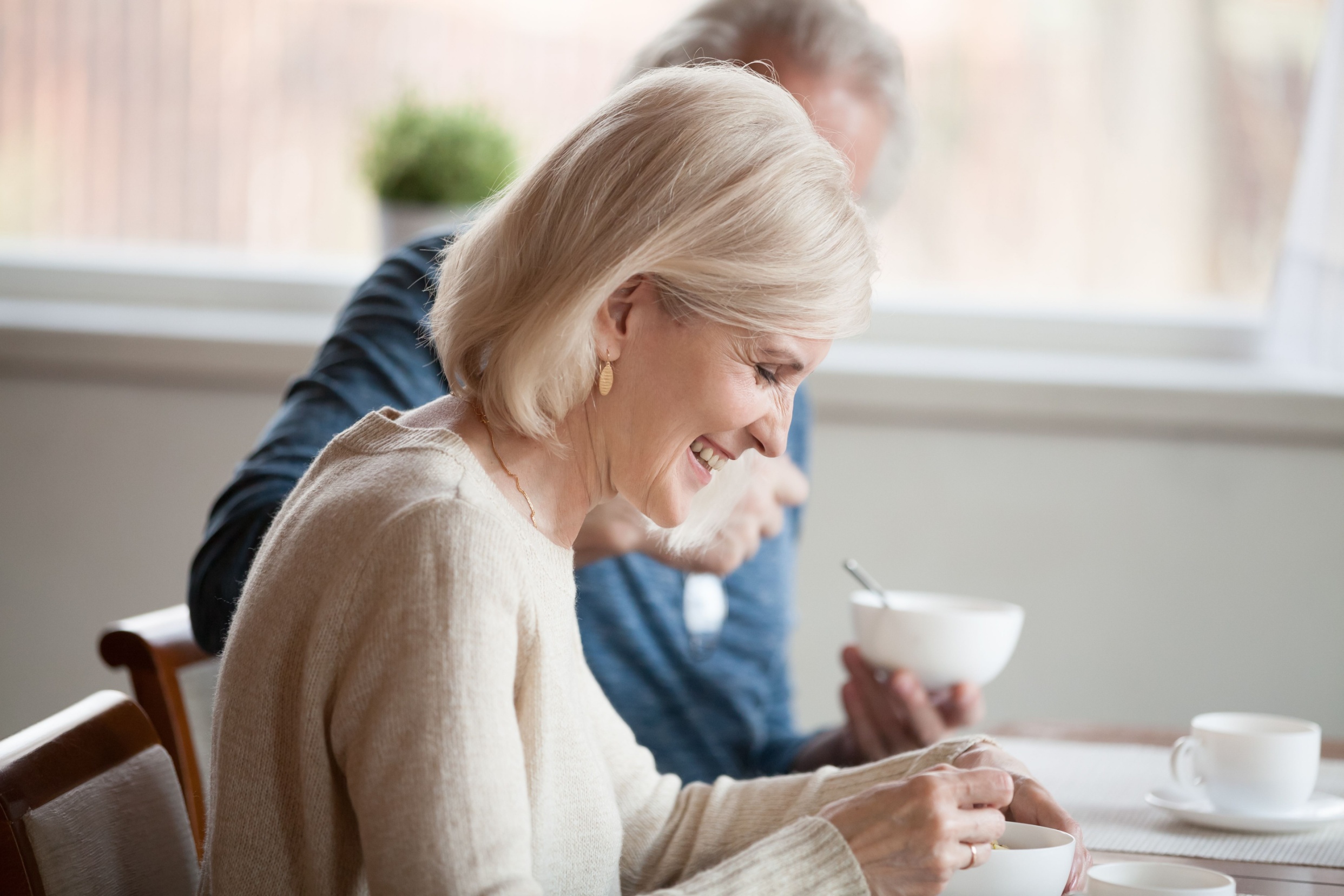 A mature couple talking while eating breakfast.