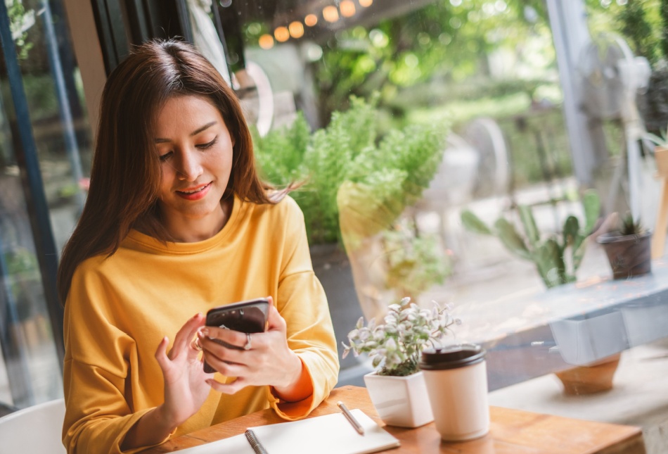 A woman using her phone in a café.