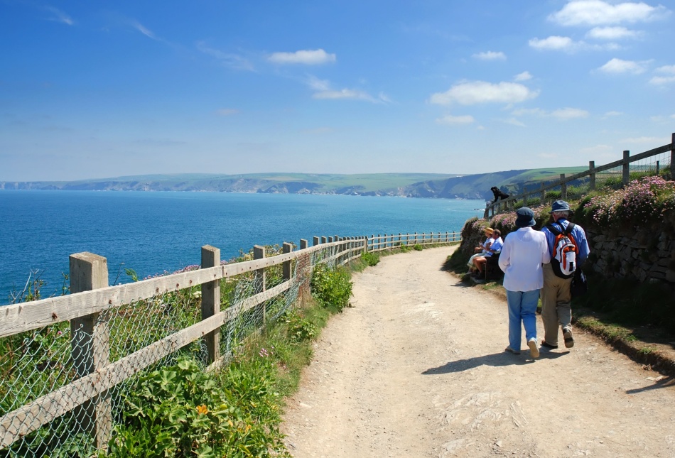 Two people walking along the coast in Port Isaac, Cornwall