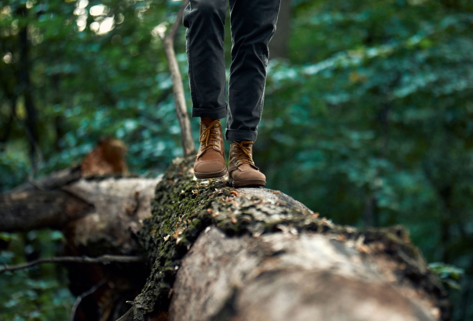 A man walking on a log.