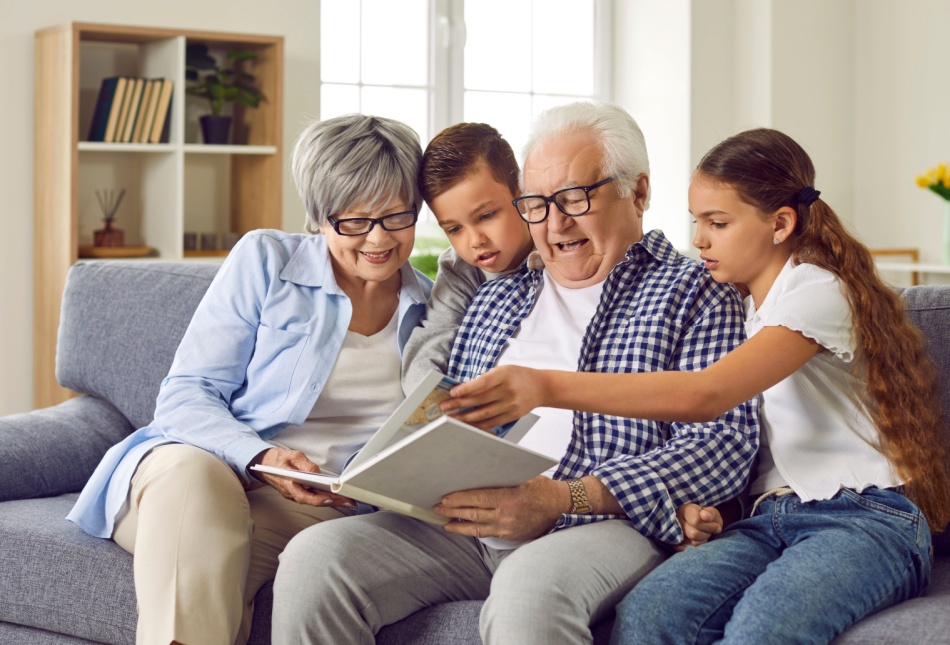 Grandparents looking at a photo album with their grandchildren.