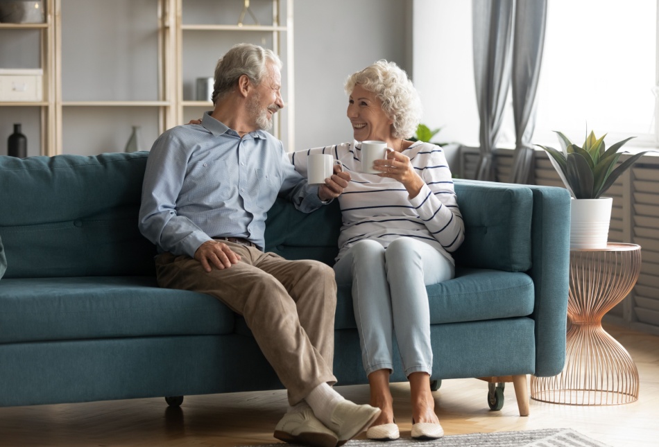 A retired couple enjoying a cup of tea in their home.