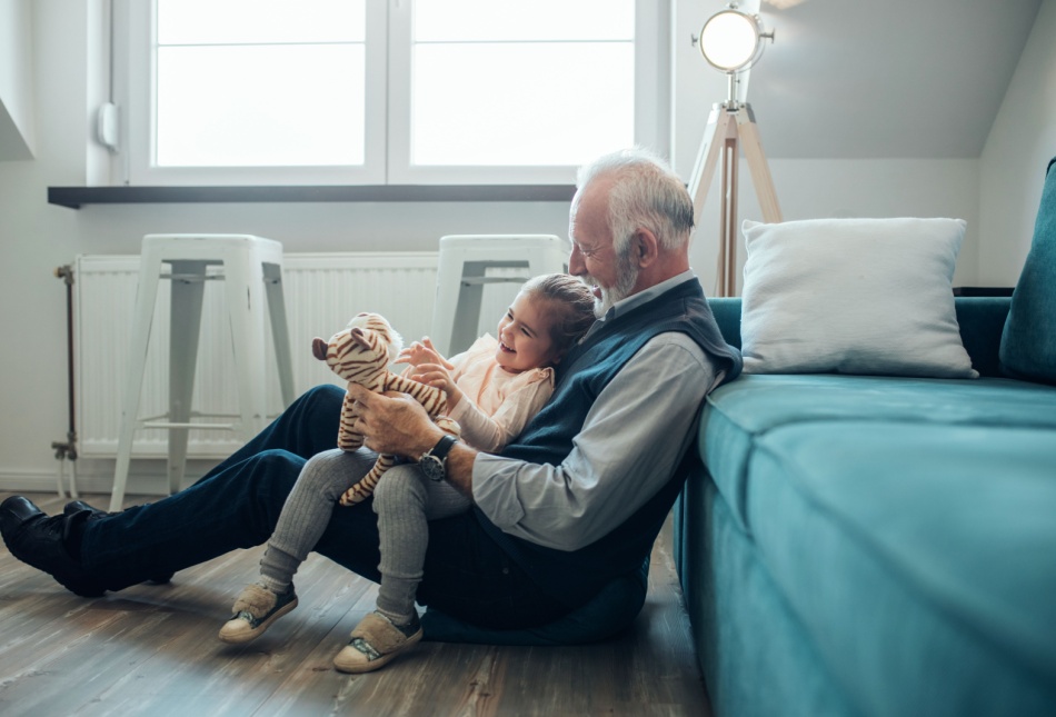A grandfather playing with his granddaughter.