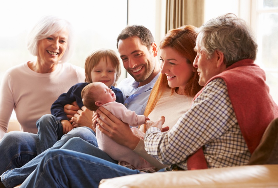 A multi-generational family sitting on the sofa.