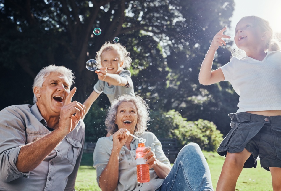 Grandparents blowing bubbles with their grandchildren.