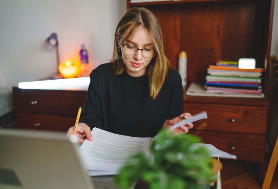 A young woman writing in a notebook