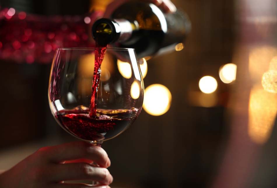 Someone pouring a glass of red wine