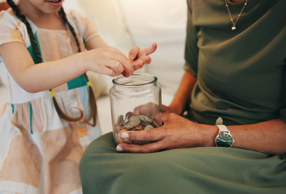 A child counting money in a jar.
