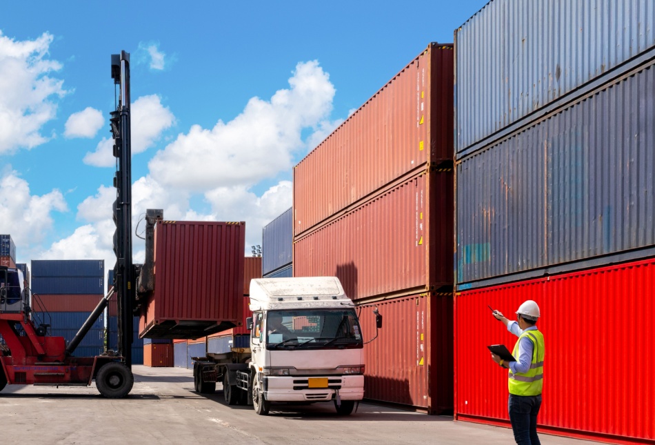 A foreman organising containers from a cargo ship.