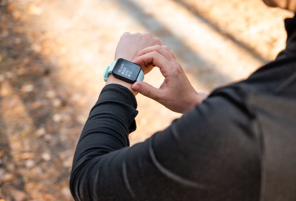 A runner looking at the time on their watch.