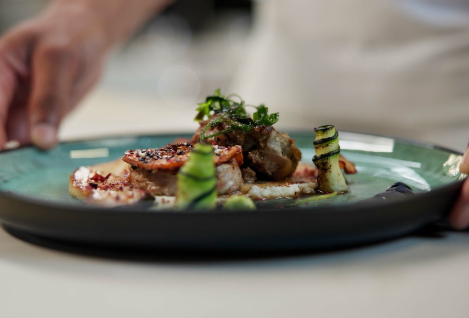 A chef prepares a dish in a fine dining restaurant.