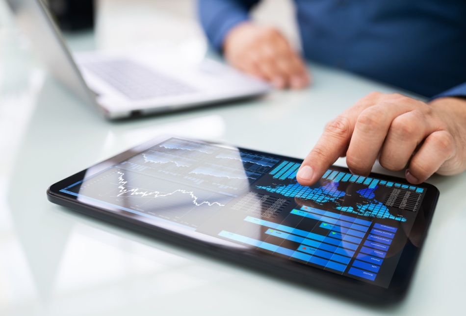 A man looking at graphs on a tablet.