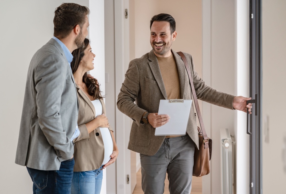 An estate agent showing a couple around a property.
