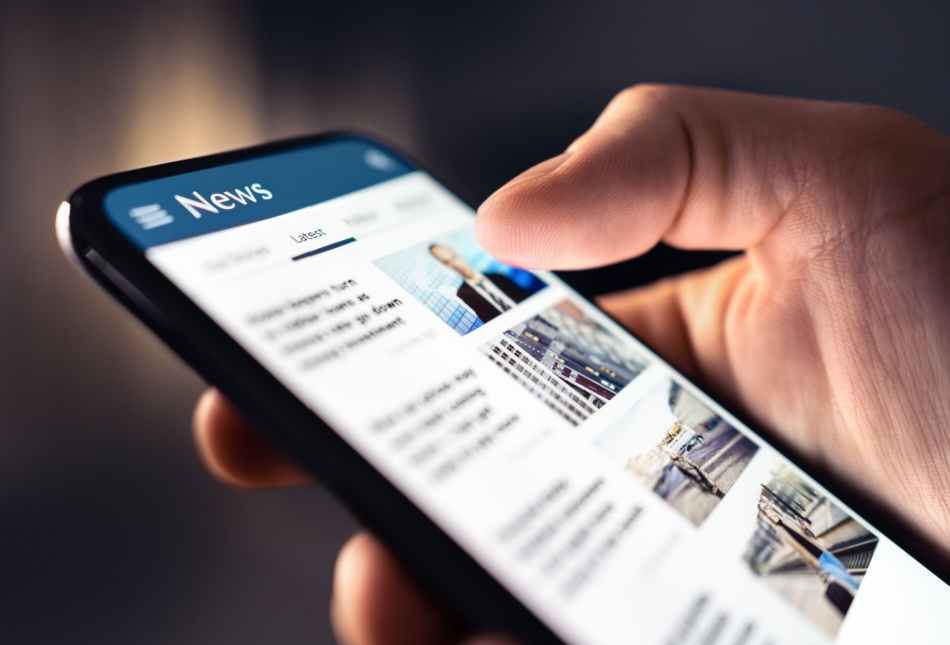 A person looking at a news feed on their phone.