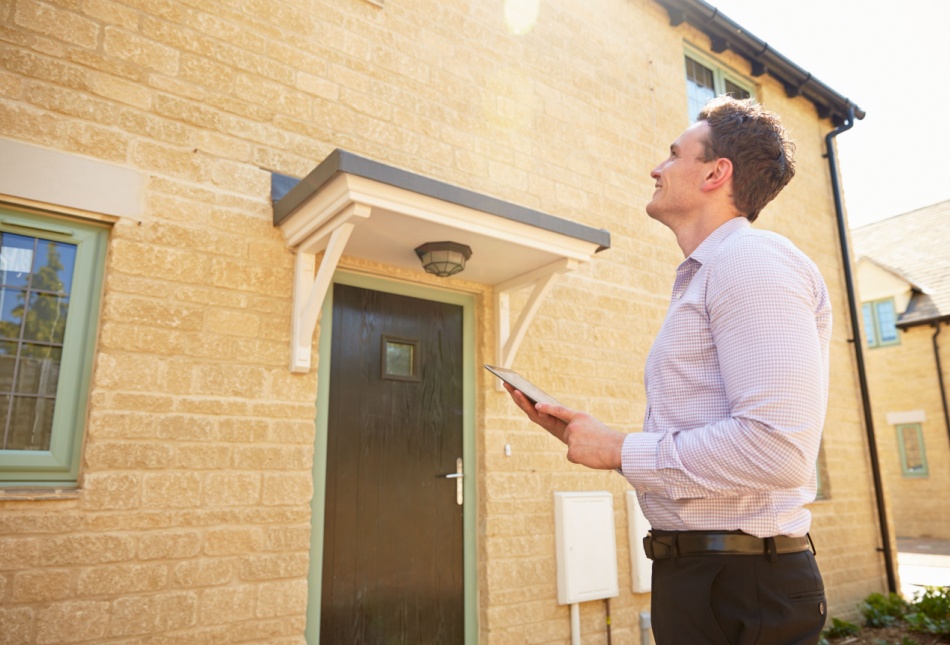 An estate agent outside of a property.