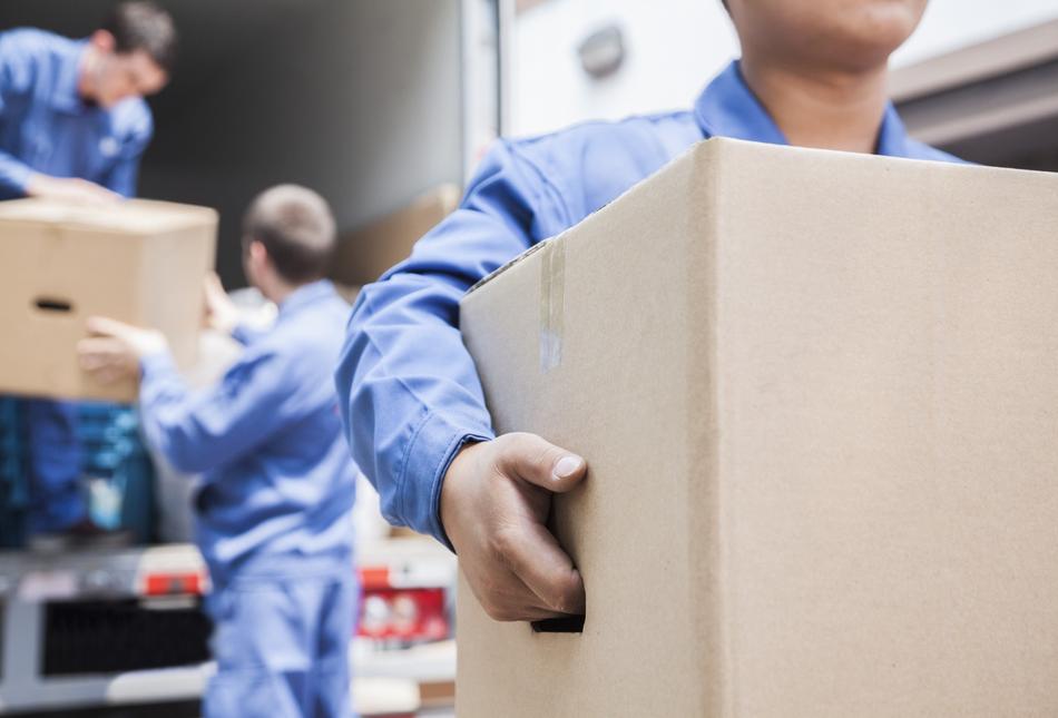 People unloading boxes from a moving van.