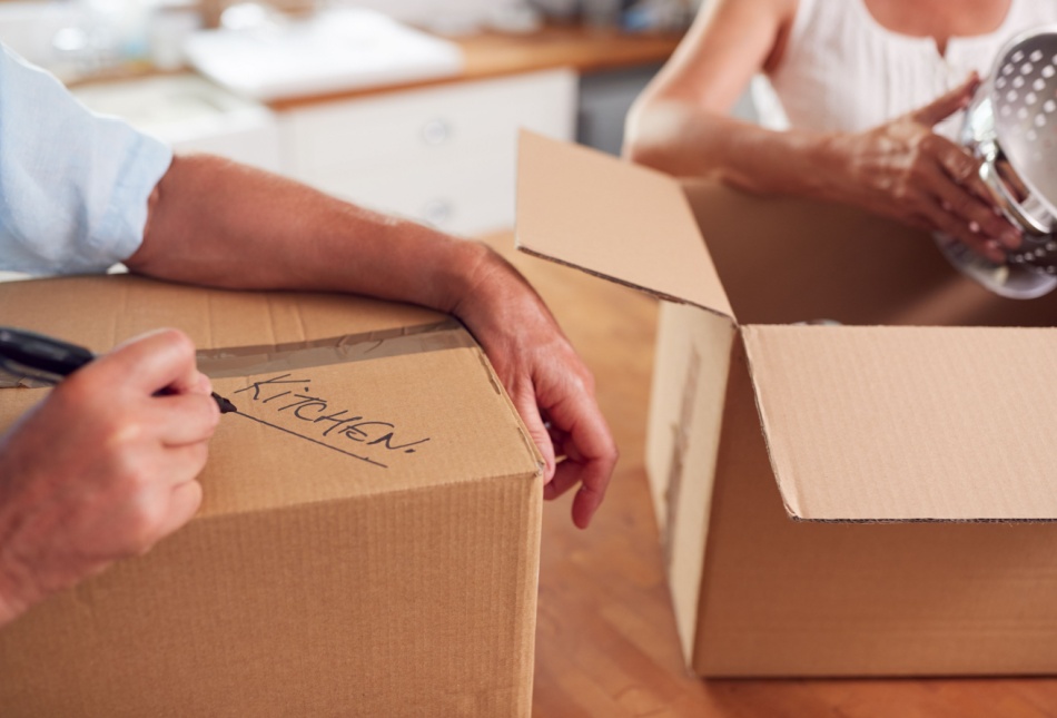 A close-up of a couple packing boxes to move home.