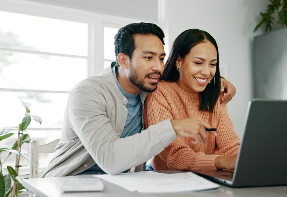 A couple looking at a laptop screen.