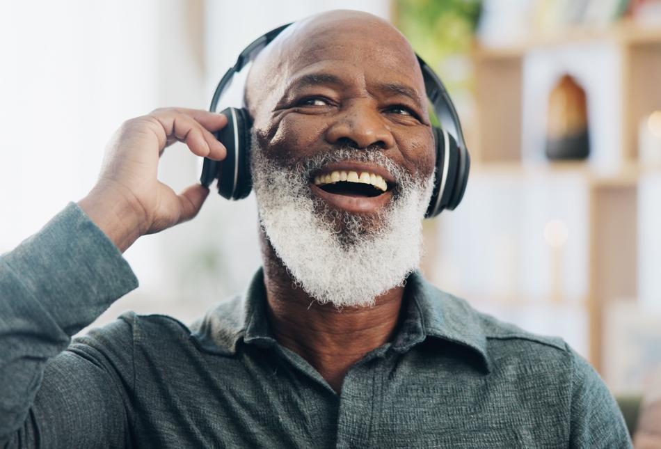 Smiling man listening to music through headphones