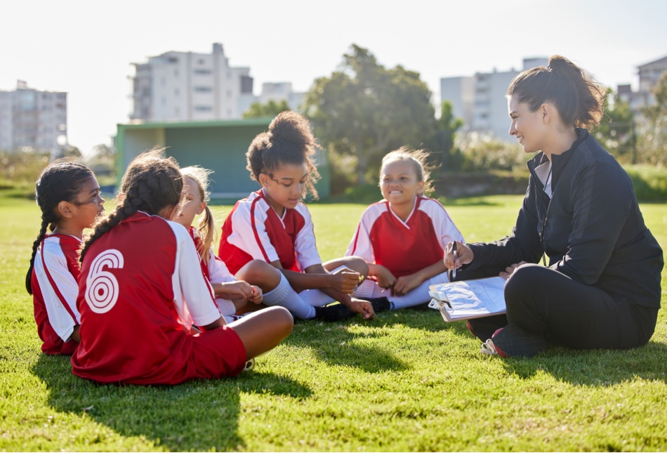 A woman coaching a girl’s football team.