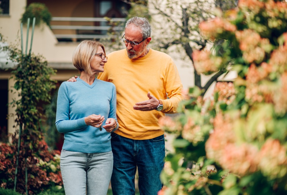 Mature couple walking outside a house