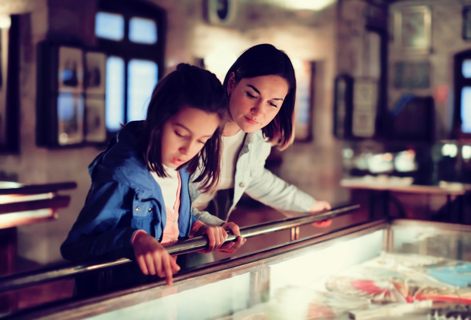 A mother and daughter viewing a museum exhibit.