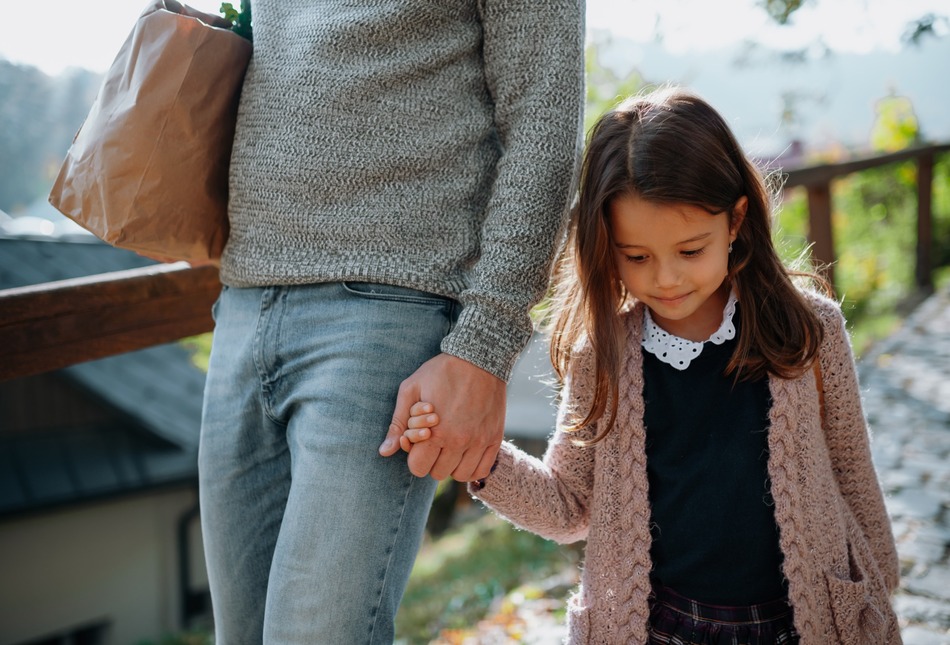 A mother and daughter holding hands.