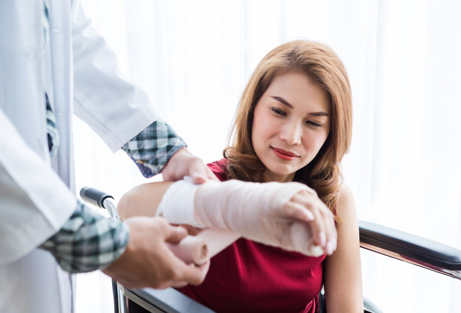 A woman having her arm placed in a cast