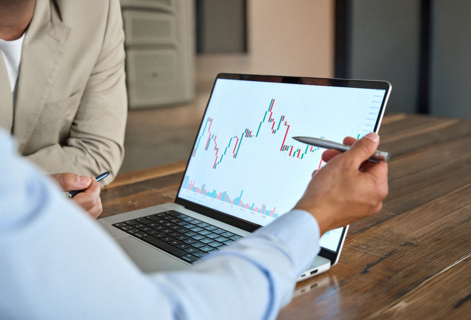 A man reviewing stock market movements on a laptop.